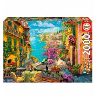 Colorful puzzle box illustration of a Mediterranean coastal village with blue sea and an outdoor café; 2000 pieces.